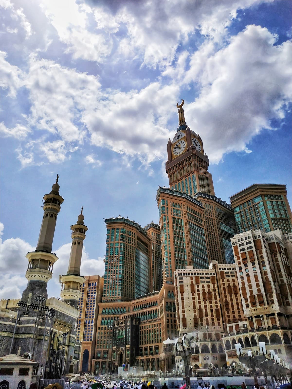 The Makkah Royal Clock Tower and minarets of the Masjid al-Haram against a blue sky