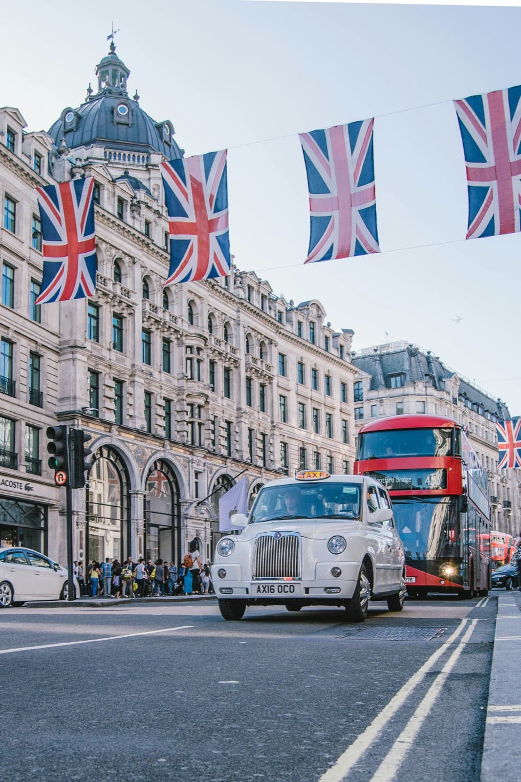 Union Jack bunting over Regent Street in London, with a taxi and a red double-decker bus